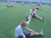 Micah Edmondson, front, stretches before a recent Dog Days workout. The 10-year-old Lawrence boy usually attends the 6 a.m. session.