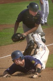 Salina's Tyler Burnett, bottom, is tagged out at home by Lawrence's Adam Emerson. The Falcons nonetheless beat the Raiders, 8-2, Tuesday in Salina.