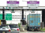 Cars and a truck go through the E-ZPass lanes in May 2003 at Exit 8A of the New Jersey Turnpike in Monroe Township, N.J. Divorce lawyers are finding that E-ZPass might be an easy way to catch cheating spouses, or to glean other useful pieces of information.