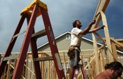 Brad Nichols, center, a carpenter with Culbertson Construction, works Thursday to secure wall supports of a home that he and his coworkers are building on Tucker Trail in northwest Lawrence. Home construction numbers in Lawrence are down, corresponding with a national trend. U.S. housing starts have reached a 10-year low, according to a federal report released Thursday.
