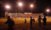 Children play a game of touch football as Lawrence High plays Free State at Haskell Stadium in this file photo.