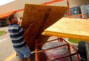 Cornelio Reteria Jr., Brownsville, Texas, places sheets of plywood into his truck Friday in preparation for Hurricane Dean.