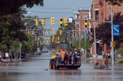 Residents ride on a front-end loader down Main Street in Ottawa, Ohio, as they are evacuated after heavy rains hit the area. Flooding was reported Wednesday in many parts of Ohio, and as the clouds clear out at the end of the week, temperatures in the 90s are expected to move in.