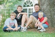 Tom Davis sits with his children, from left, Matthew, 12, Jacob, 13, and Ethan, 6, in Chatham, Va. Davis lost his wife, Elizabeth, in 2000, after she gave birth to Ethan. U.S. women are dying from childbirth at the highest rate in decades, new government figures show.