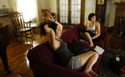 Kansas University senior Marcela Telles, Brazil, left, socializes with junior Kate Mallula, Roeland Park, on Monday in the living room of Watkins scholarship hall. Watkins is one of several buildings on the KU campus that are scheduled to receive electrical wiring updates.