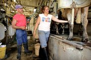 Tim Iwig, owner of Iwig Family Dairy, watches employee Melody Buford while milking cows July 6 in Topeka. There was a time - long before the Internet, cell phones and $3-per-gallon gasoline - when milk, not water, came in bottles. And glass bottles at that. Many older consumers recall glass bottles fondly as providing colder, creamier, fresher-tasting milk.