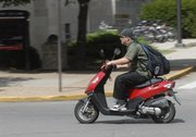 Kansas University freshman Julian Myers, of Lebanon, Ore., sets off on his scooter Friday on the KU campus.