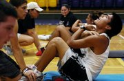 Haskell Indian Nations University freshman Dylan Ware, Fort Washakie, Wyo., Shoshone Tribe, right, works through a set of sit-ups with his classmates during a class called Body Weight Control on Tuesday in the Coffin Sports Complex gymnasium. Steadying his feet is Haskell freshman Chance Allensworth, of Valliant, Okla., and the Mississippi Choctaw Tribe.