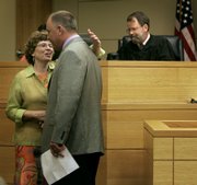 Toby Young, left, gives her attorney, Jim Yoakum, a hug after being sentenced Wednesday, July 11, 2006, in Leavenworth. Young was given 21 months in prison for her role in helping a convicted murderer escape from the Lansing Correctional Facility in a dog crate.