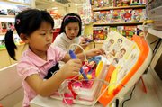 Chinese children try out toys Friday at a mall in Shanghai, China. Recall systems for unsafe food products and toys went into effect in China on Friday as part of a bid to improve product safety, state media said.