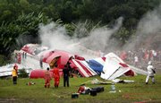 The wreckage of a One-Two-Go passenger plane sits on the side of the runway after it crashed while attempting to land at Phuket International Airport in southern Thailand. The plane filled with foreign tourists crashed Sunday in heavy rain on the tourist island of Phuket, leaving at least 91 people dead, officials said. See story, page 2A.