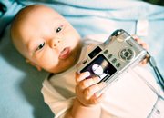 Five-month-old Jordan Short holds a camera belonging to his mother, Amy Short, whose photo is seen on the camera's screen in a posed photo at their home in East Alton, Ill. Thanks to cheap and easy-to-use recording devices - digital cameras, camcorders and camera phones - today's children are becoming the most documented generation ever.