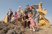 With a bulldozer as a backdrop, Jana Henry Faber (from right), two-year-old Ella Henry and Robert Henry along with other family members along with Joe Reardon (center), Mayor/CEO of Unified Government of Wyandotte County, turn over the first loads of dirt in a ground breaking ceremony Tuesday for the new Schlitterbahn Vacation Village. The Henry family, owners of three other resorts, were on hand for the first expansion outside of Texas for a $750 million year round retail entertainment and water-park destination that will be located on a 370-acre track near Village West in Kansas City, Kansas. .