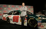 Dale Earnhardt Jr. poses with his new NASCAR race car. Earnhardt revealed his new car Wednesday in Dallas.