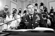 Gen. David Petraeus is surrounded by cameras as he prepares to address members of the U.S. House last week.