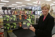 Kathy Kelly, president of Kroger Co.'s Personal Finance division, shows a credit card brochure next to a display at a Kroger grocery store in Union, Ky. Kroger, the nation's largest traditional grocer that also owns Dillons, a Hutchinson-based chain of grocery stores, has been expanding its financial services business during the past three years.