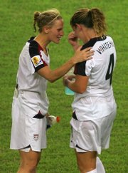 United States soccer players Kristine Lilly, left, and Cat Whitehill console each other after losing to Brazil. The Americans fell, 4-0, on Thursday in Hangzhou, China.