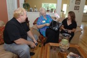 Avon advanced unit leaders Bobby McKinney, left, and his wife, Joy, deliver an order to Lya Delcid on June 23 at her home in Orlando, Fla. McKinney is one of a growing number of male salesmen supplementing their income selling products from the $9-billion-a-year beauty company. McKinney along with his wife did about $800,000 in sales last year. He has about 170 sales reps under him.