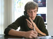 Obama campaign volunteer Chris Elsenbast, of Ames, Iowa, works the phone Wednesday at the Obama campaign headquarters in Ames. Iowa's presidential caucuses are typically a gray-haired affair, but this year candidates are working to entice college students and even high school kids to show up.