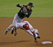 Arizona's Justin Upton is called for interference as he takes out Colorado second baseman Kazuo Matsui during Game 1 of the National League Championship Series. The Rockies won, 5-1, on Thursday night in Phoenix.