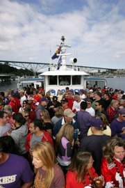 Fans of the Washington and Ohio State teams ride the Good Time II Husky Boat past the Aurora Bridge on the way to the game Sept. 15 at Husky Stadium.