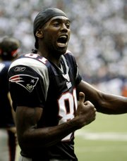 New England Patriots wide receiver Randy Moss reacts on the sideline in the fourth quarter against the Dallas Cowboys in their showdown. New England won, 48-27, Sunday in Irving, Texas.