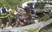 Rescue personnel inspect the remains of a home destroyed by a tornado Thursday in Pensacola, Fla. The tornado touched down in Pensacola, damaging the city's major shopping mall as a line of violent thunderstorms made their way across the western Florida Panhandle on Thursday.