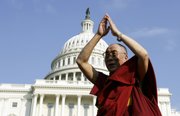 The Dalai Lama gestures on the West Steps of the Capitol on Wednesday in Washington following a ceremony where he received the Congressional Gold Medal. President Bush personally presented the medal and used the opportunity to advocate for religious freedom.