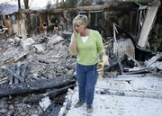 Rae Woods and her family look through the remains of their home Wednesday in Poway, Calif. Eight homes burned in their development in eastern San Diego County. The winds were calmer Wednesday, giving crews a chance to fight back against some blazes.