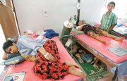 A pregnant Myanmar patient, second from right, is supported before her delivery by her husband, right, and their elder children, under the bed, Oct. 11 at Mae Tao Clinic in Mae Sot, Thailand.