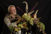 Several natural elements like winterberry and holly can be used to create indoor floral and plant arrangements to last through the holiday season. Pictured with the arrangement is John McCaffrey, owner of BitterSweet Floral and Design, 1407 Mass.