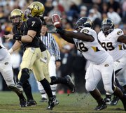 Missouri defensive lineman Tommy Chavis, right, knocks the ball out of the hands of Colorado quarterback Cody Hawkins. Mizzou ripped CU, 55-10, Saturday in Boulder, Colo.