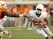 Texas running back jamaal Charles, right, finds a gap in the Oklahoma State defensive line. Charles scored three touchdowns, including two in the fourth quarter, in the Longhorns' 38-35 comeback victory against the Cowboys on Saturday in Stillwater, Okla.