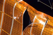 This photo released by NASA shows a two-foot tear in the solar array material on Saturday a few hours before spacewalker Scott Parazynski patched it.