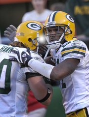 Green Bay's Charles Woodson, right, celebrates with teammate A.J. Hawk after Woodson's fourth-quarter interception. The pick helped the Packers beat the Chiefs, 33-22, Sunday in Kansas City, Mo.