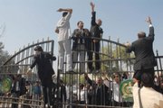 Pakistani lawyers climb on the closed gates of the District Courts chanting anti-Musharraf slogans in Multan, Pakistan. Lawyers again clashed with police as President Pervez Musharraf's government considered when to hold elections amid growing international pressure to end emergency rule and restore democracy.