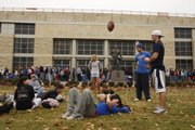 Kansas University student football fans wait Monday in front of Allen Fieldhouse for tickets to the KU-Missouri game Nov. 24. Ryan Leiker passed the time by tossing a football to friends as he rested in the grass. Hundreds of KU students camped out all night to pick up tickets they had purchased for the game.