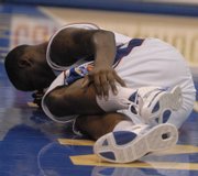 Kansas guard Sherron Collins grabs his ankle after hitting the deck. Collins returned to the game after the injury Sunday, but had surgery Monday to repair a pre-existing stress fracture.