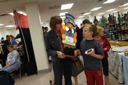 Debbie Fuller, left, and Luke Miller, 9, chat while browsing at the Holiday Bazaar. The craft fair was expected to raise about $8,000 for Lawrence Parks and Recreation.