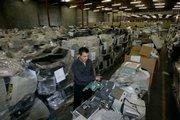 John Bekiaris, chief executive of San Francisco-based HMR USA Inc., sorts through a warehouse filled with discarded computers. HMR USA collects and disposes of unwanted IT equipment from Bay Area businesses. "There are a lot of people getting away with exporting e-waste," Bekiaris says. "Anyone who&squot;s disposing of their computer equipment really needs to do a thorough inspection of the vendors they use."