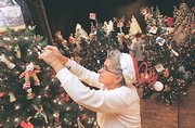 Charlotte Rodecap, of Perry, puts the finishing touches on the "Merry Old McChristmas" tree during the 2006 Festival of Trees setup. The public can view the 2007 exhibit starting Monday at Liberty Hall, 642 Mass.