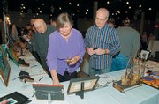 A painting titled "Pastoral V" captures the attention of, from left, James Rowland, Kim Kreicker and Joey Tillman during Douglas County AIDS Project&squot;s Red Ribbon Art Auction in this 2006 file photo. Doors open for the 2007 event at 5 p.m. Dec. 2.