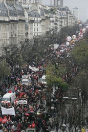 Thousands of civil servants demonstrate along a boulevard in Paris. Civil servants, from teachers to postal workers, began a mass walkout across France on Tuesday, the seventh day of a transport strike that has caused havoc on French rails.