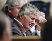 Raynella Dossett Leath, 59, weeps as she listens to prosecutors Friday in Knoxville, Tenn., talk about circumstances surrounding the death of her then-husband, District Attorney Ed Dossett, who was found dead in his cattle lot in 1992. Investigators thought the herd had accidentally trampled him to death. Now they believe the trampling may have covered up his murder for 15 years.
