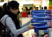 A local consumer buys boxes of toys at a department store Sunday in Shanghai, China. When it comes to toys for their own children, parents who can afford it buy foreign-brand toys.