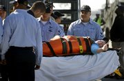 Laura Montero, 14, gives a thumbs up Tuesday after she is handed over to medical personnel on shore in Coronado, Calif., by members of the USS Ronald Reagan. Montero had emergency surgery aboard the Reagan after her appendix burst. She was rescued by a Navy helicopter from the cruise ship on which she was a passenger.