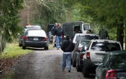 King County Sheriff Deputies gather near a rural property east of Seattle where six people, likely three generations of a family, were found dead Wednesday in Carnation, Wash.