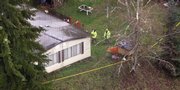 Investigators look at a scene outside the home southeast of Carnation, Wash., where six people were found dead Wednesday afternoon.