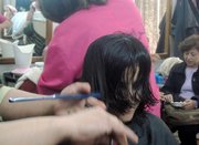 A hairdresser trims a young woman's locks Sunday in a salon where ladies gather to primp and catch up on gossip in a Shiite-dominated neighborhood in eastern Baghdad. The neighborhood is considered relatively safe, unlike many areas in mostly Sunni west Baghdad where extremists rule. According to the extremists' harsh interpretations of Islam, women should not look beautiful in public. Extremists have threatened hairdressers, blown up their shops and even killed some. Many now work in secret salons, only serving people they know, in their own houses.