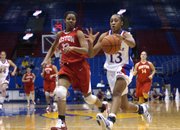 Kansas senior Taylor McIntosh (13) brings the ball downcourt against Boston University's Jesyka Burks-Wiley on a fast break. McIntosh led the Jayhawks to a 71-57 victory Sunday at Allen Fieldhouse.